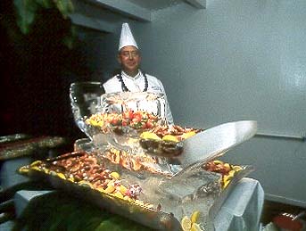 Our chef, posing with a magnificent ice sculpture and luscious tropical fruit. Copyright Milton Fullman